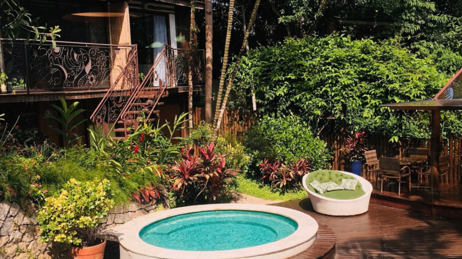 Área externa com piscina e jardim tropical